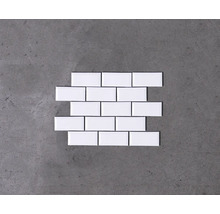 Weisse Keramikfliesen im Halbversatz auf grauem Untergrund