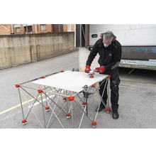 Fliesenschneider mit Fliese auf Schneidetisch und Arbeiter