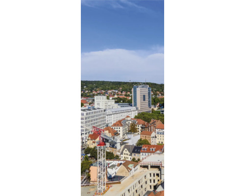Panoramaaufnahme einer Stadt mit verschiedenen Gebäuden und einem Baukran.