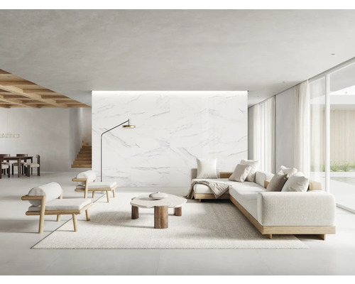 Heller Wohnraum mit Sofa, Sesseln, Teppich und Marmorwand
