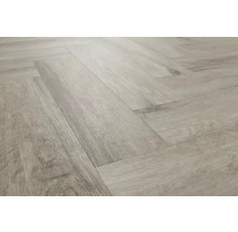 Verlegung von hellem Laminat im Fischgrätmuster.