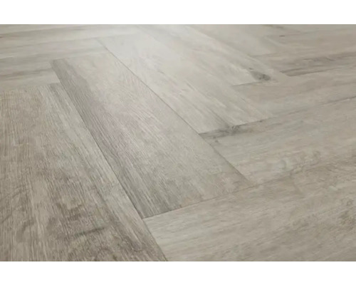 Verlegung von hellem Laminat im Fischgrätmuster.