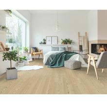Helles Schlafzimmer mit Laminatboden in heller Holzoptik, ausgestattet mit Bett, Sesseln, Zimmerpflanzen und einem gemütlichen Kamin.