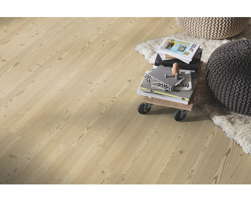 Laminatboden in heller Holzoptik mit Kiefer-Maserung in einem hellen Wohnzimmer mit Teppich und Sitzkissen.