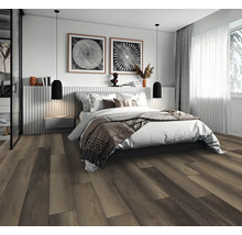 Modernes Schlafzimmer mit dunklem Boden in Holzoptik, Doppelbett, zwei schwarzen Pendelleuchten und hellem Fenster.