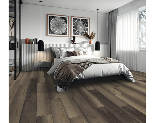 Modernes Schlafzimmer mit dunklem Boden in Holzoptik, Doppelbett, zwei schwarzen Pendelleuchten und hellem Fenster.