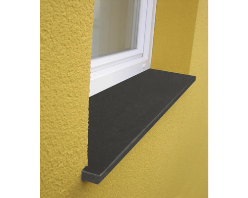 Außenfensterbank in Steinoptik montiert an einer Hausfassade unter einem Fenster.