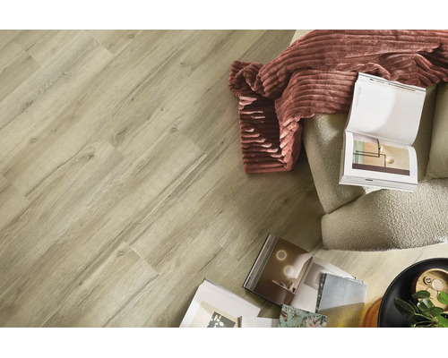 Bodenbelag in Holzoptik in einem hellen Wohnzimmer mit Sessel, Decke und Zeitschriften.