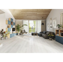Helles Wohnzimmer mit modernem Bodenbelag in Holzoptik, dunklem Sofa, Holzdecke und verschiedenen Zimmerpflanzen.