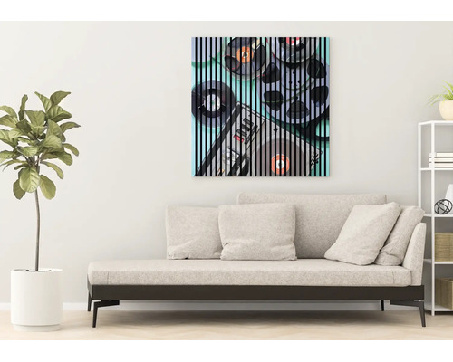 Modernes Wohnzimmer mit hellem Sofa, einer Zimmerpflanze und einem quadratischen Wandbild mit Retro-Audio-Motiv und schwarzen Streifen.