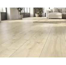 Heller Laminatboden in Eichenoptik in einem lichtdurchfluteten Wohnzimmer mit Sofa und Teppich.