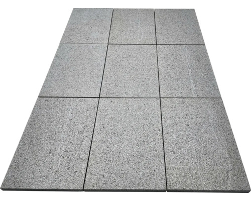 Neun rechteckige Terrassenplatten aus Granit mit strukturierter Oberfläche, im Raster von drei mal drei verlegt.