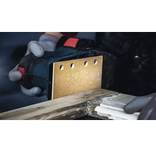 Eine Person schleift Holz mit einem Schwingschleifer.