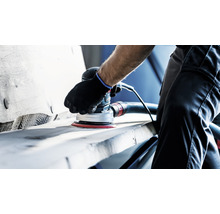 Handwerker verwendet einen Exzenterschleifer mit Staubabsaugung zum Schleifen von Holz