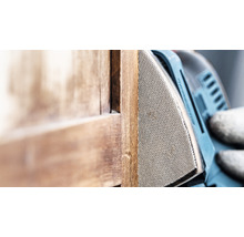 Dreieckschleifer beim Schleifen von Holz