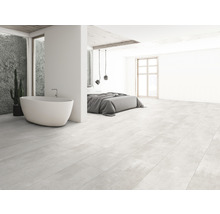 Heller Raum mit Badewanne, Bett und Fliesenboden in Holzoptik