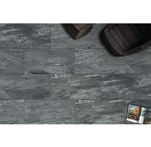 Fliesen mit Steinoptik, zwei Korbsessel und eine Zeitschrift