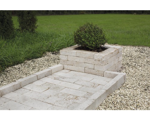 Gartenszene mit Pflanzkasten und Gehweg aus Travertin