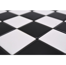 Nahaufnahme von quadratischen, abwechselnd schwarzen und weißen Bodenfliesen