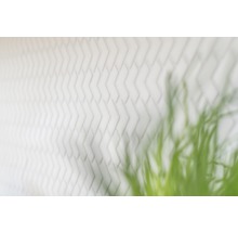 Weiße Ziegelwand mit Fischgrätenmuster