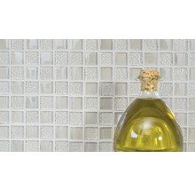 Glasmosaikfliesen mit einer Flasche Öl im Vordergrund