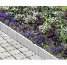 Beetbegrenzung aus Beton mit Blumen und Pflastersteinen