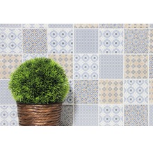 Dekorative Wand mit Patchwork-Fliesen und Pflanze im Korb