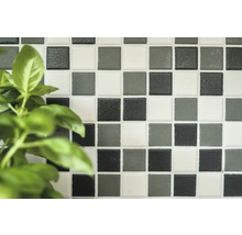 Quadratische Mosaikfliesen an einer Wand.