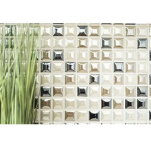 Detailaufnahme einer Wand mit Mosaikfliesen und Ziergras