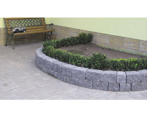 Beetbegrenzung aus Naturstein mit Bepflanzung im Garten.