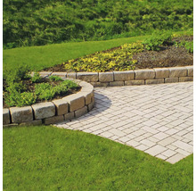 Garten mit Pflastersteinen und Natursteinmauer