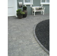 Außenaufnahme eines Hauses mit gepflastertem Gehweg und Zierkies