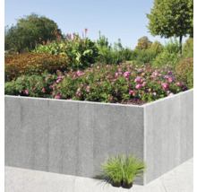 Hochbeet aus Stein mit blühenden Pflanzen und Sträuchern im Garten