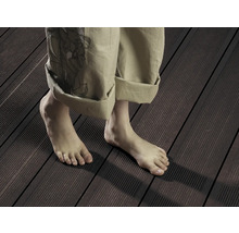 Person steht barfuß auf Terrassendielen