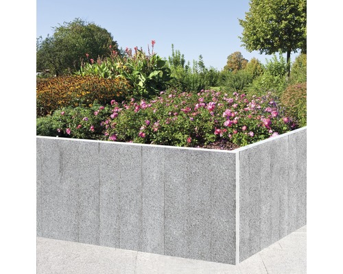 Hochbeet aus Stein mit Blumenbepflanzung im Garten