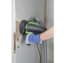 Handwerker schleift Wand mit Mauernutfräse mit Staubabsaugung