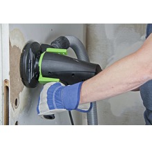Handwerker beim Schleifen einer Wand mit einem Trockenbauschleifer mit Staubabsaugung