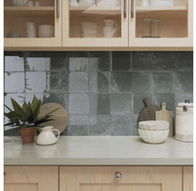 Küchenszene mit Spülbecken, Fliesenwand und Küchenutensilien