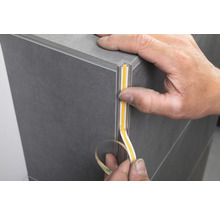 Person befestigt LED Streifen in einem Profil an einer Fliese