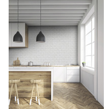 Helle Küche mit Holzboden, weißen Schränken und einer Backsteinmauer