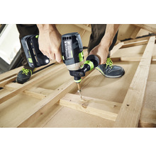 Eine Person benutzt einen Akku-Schlagschrauber, um eine Schraube in ein Holzbrett zu schrauben.