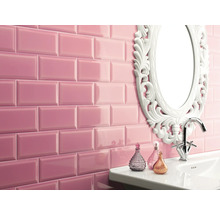 Badezimmer mit rosa glänzenden Metrofliesen, Waschbecken, Spiegel mit verschnörkeltem Rahmen und Armatur