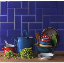 Dekorative Küchenszene mit blauen Fliesen, Kochgeschirr und Erbsen