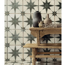 Wand- und Bodenfliesen mit Sternmuster hinter einem Holztisch mit Vasen