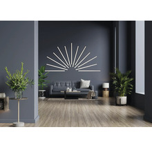 Wohnzimmer mit Sofa, Couchtisch, Zimmerpflanzen und Wandleuchte in Streifenform