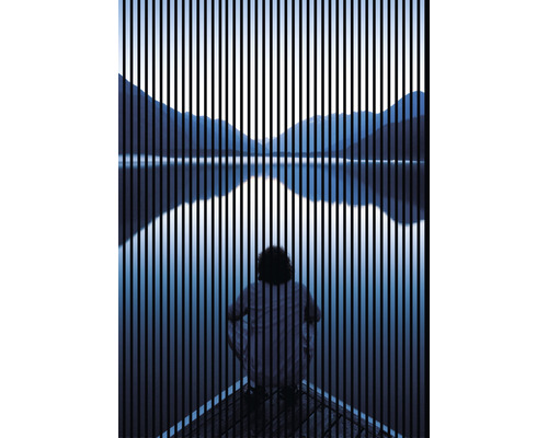 Person sitzt am See, Bergpanorama im Hintergrund