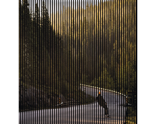 Dekoratives Gitter vor Landschaft mit Straße und Person auf Skateboard