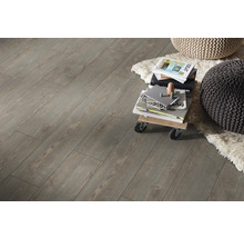 Innenaufnahme von Laminatboden mit Holzoptik, mit einem kleinen Rollwagen, Büchern und zwei Sitzkissen