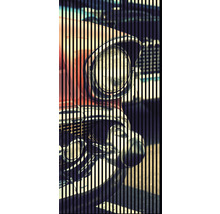 Detailansicht eines Oldtimer-Scheinwerfers hinter vertikalen Streifen