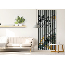 Wohnzimmer mit Sofa, Beistelltisch, Wandregal mit Dekoration und einem Wandbild mit Fahrradmotiv.